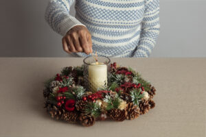 Home 9 woman lighting wreath candle fire